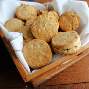 Basket of golden brown biscuits with crease in the middle, ready to eat.