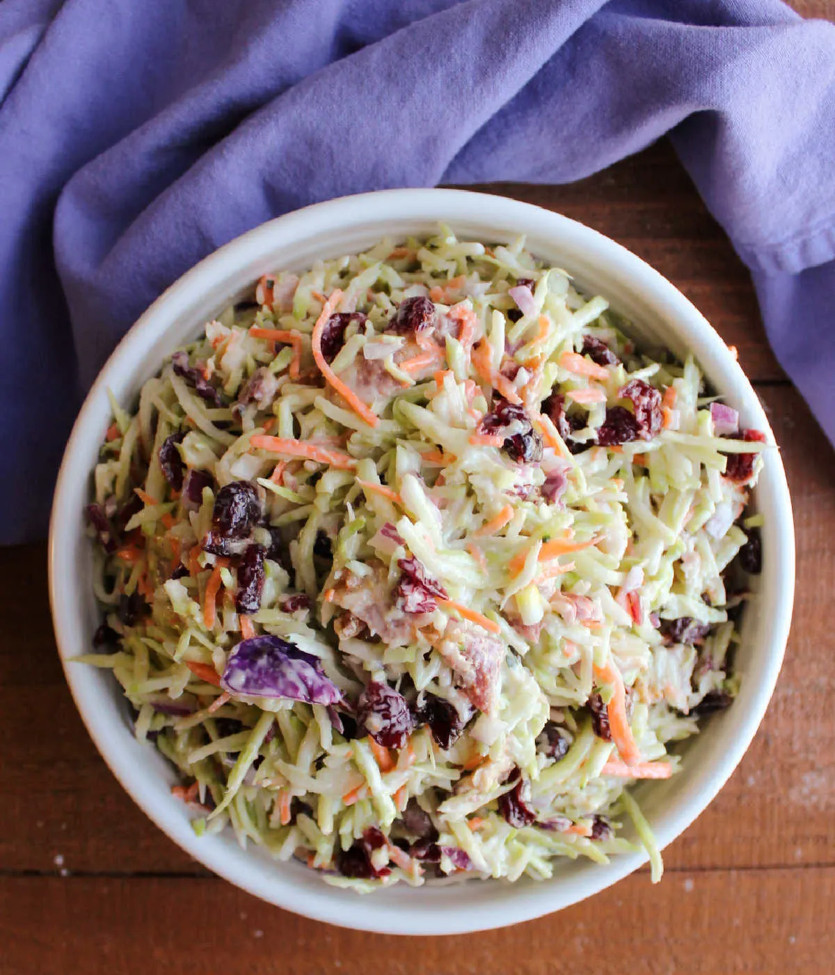 Serving bowl filled with broccoli slaw with bacon and cranberries, ready to eat. 
