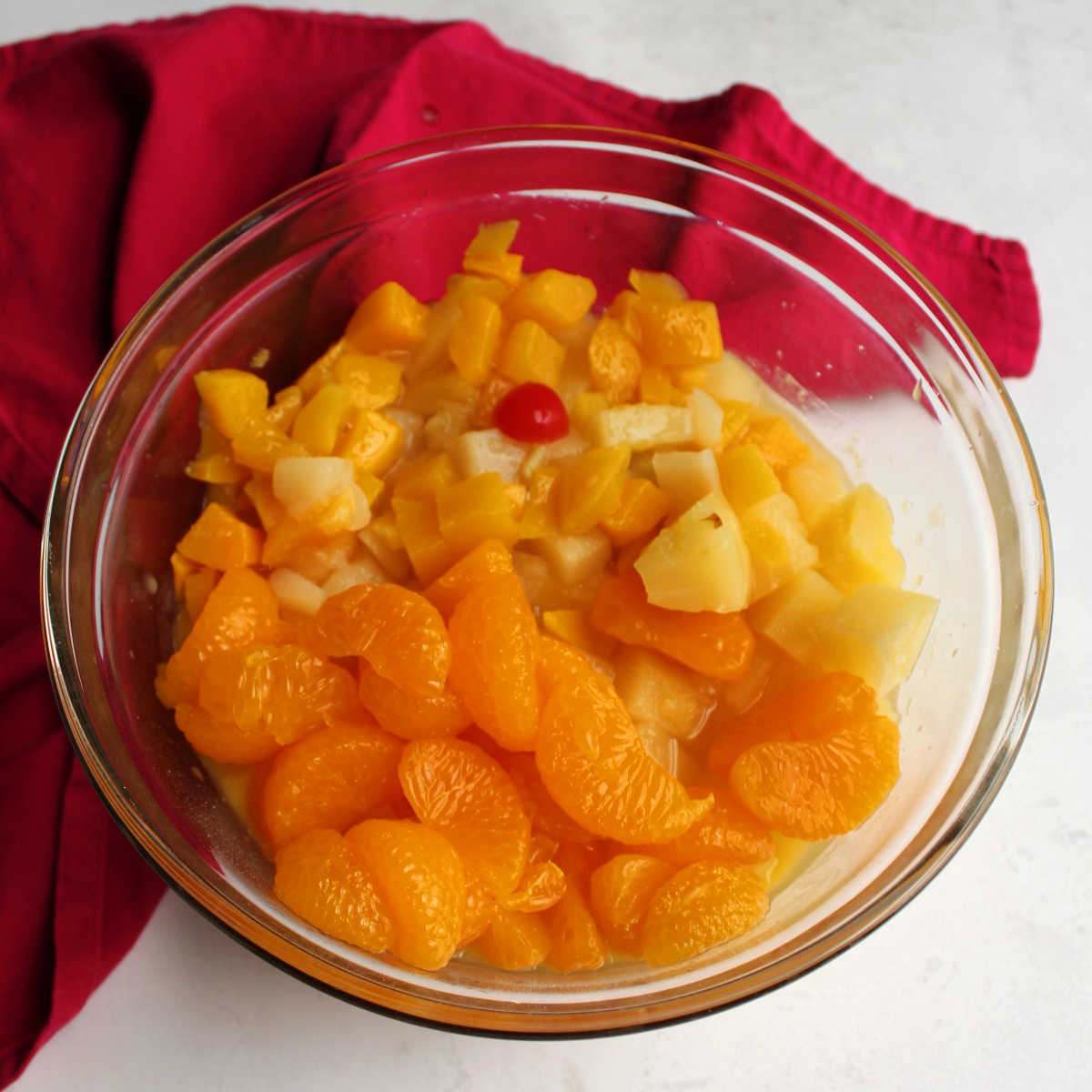 Drained oranges, pineapple and fruit cocktail on top dressing mixture.