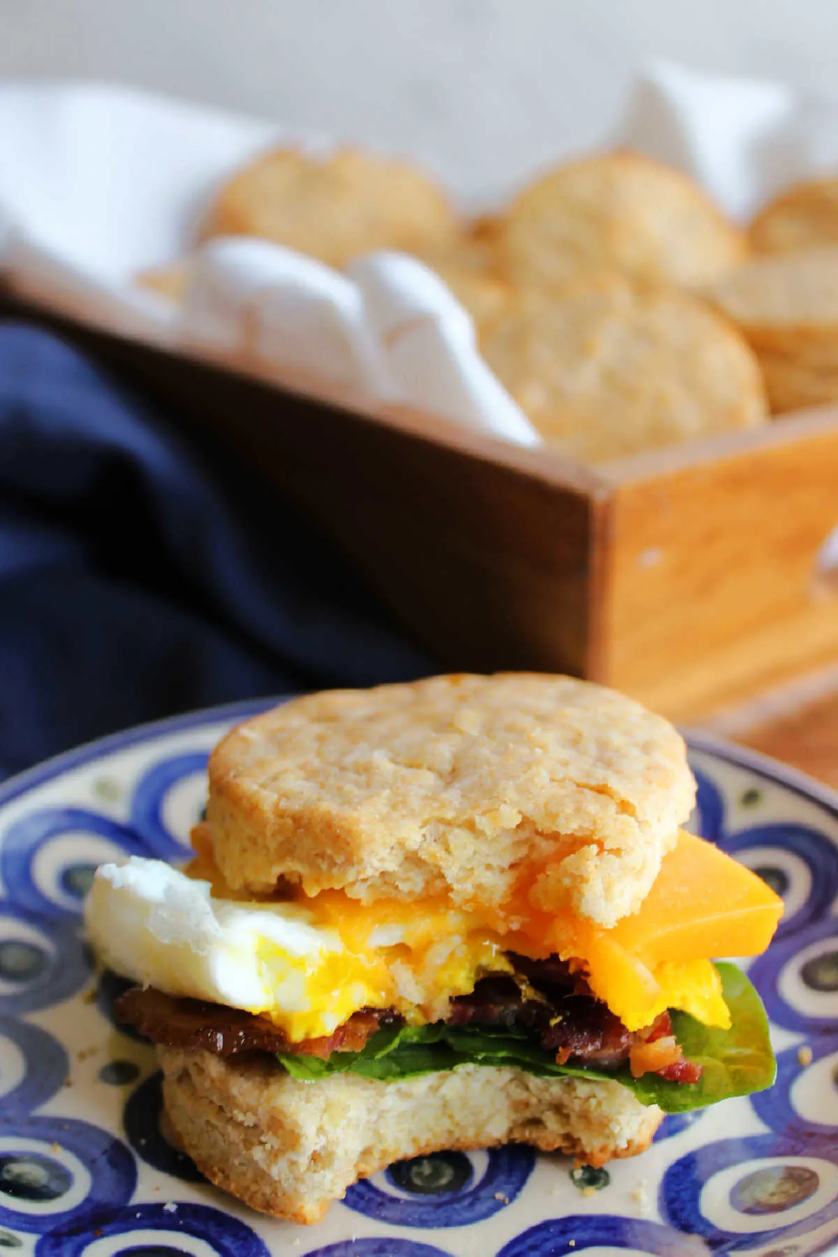 Biscuit made into a breakfast sandwich with eggs, cheddar, bacon and spinach.