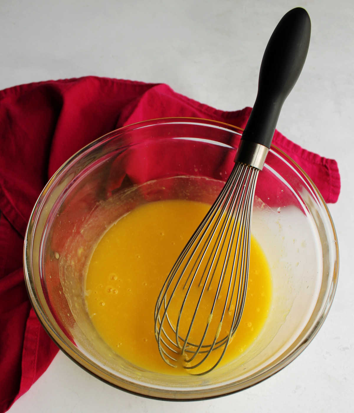 Mixing bowl with pineapple juice and pudding mixed together to make dressing for fruit salad.