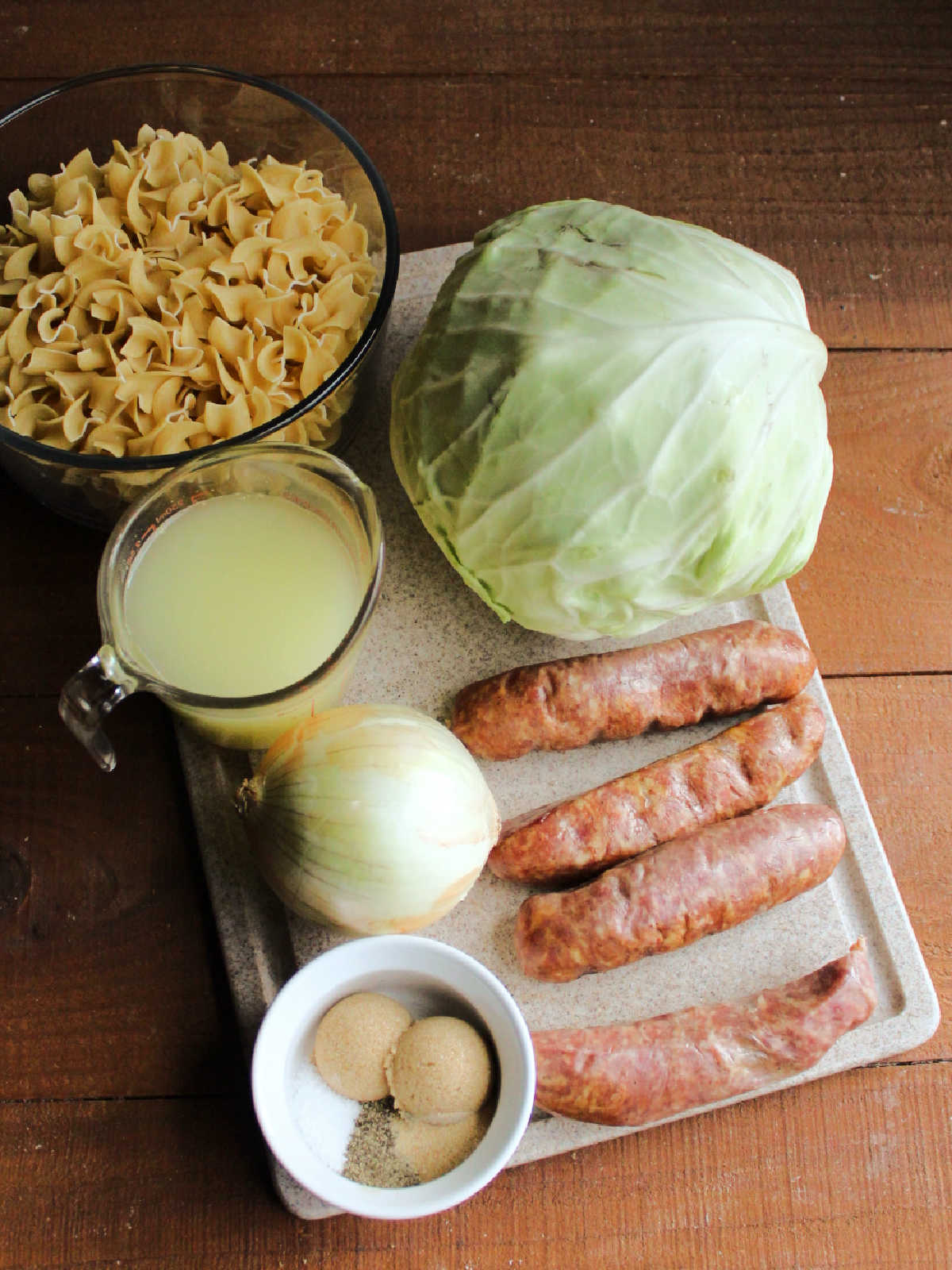 Ingredients including cabbage, kielbasa, onion, chicken broth, brown sugar, salt, pepper, garlic powder and egg noodles ready to be made into haluski.
