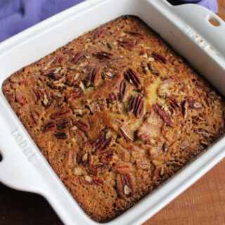 Baked pecan pudding cake with golden top studded with lots of pecans.