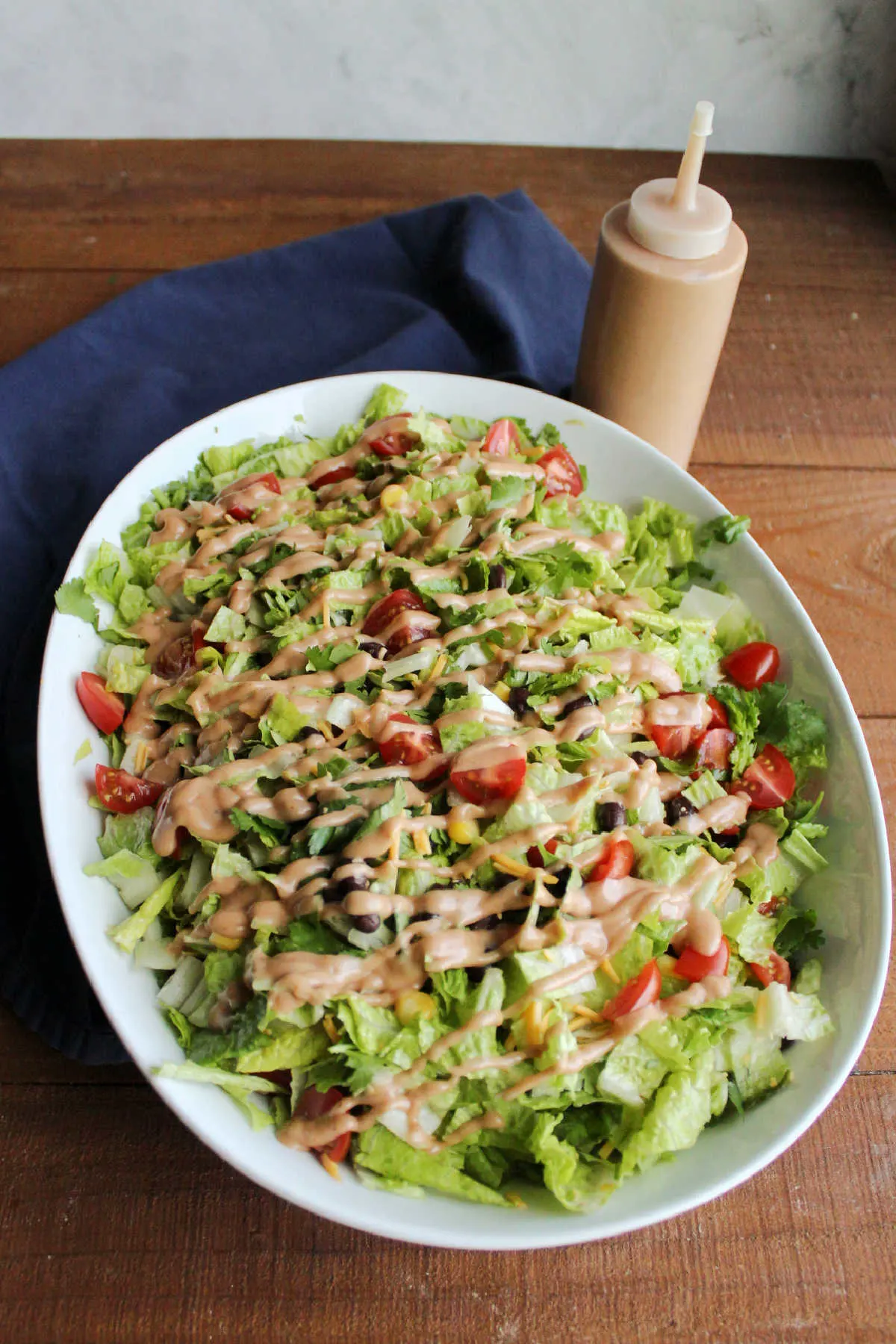 Cowboy salad topping tossed with lettuce and topped with drizzled creamy bbq dressing.