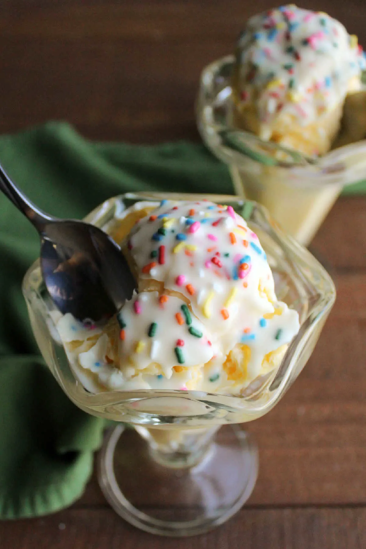 Spoon cracking through unicorn magic shell that has hardened over ice cream.
