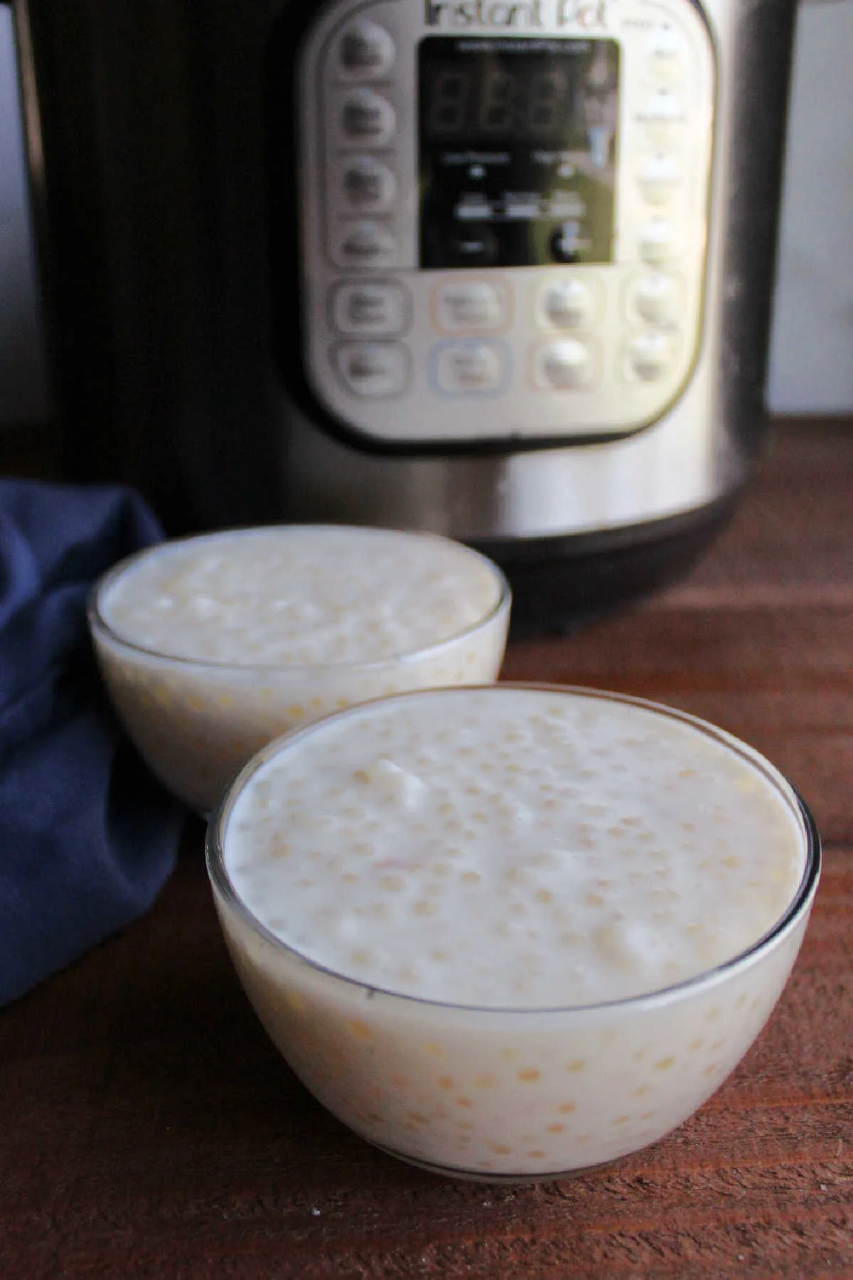Small bowls of homemade vanilla tapioca pudding in front of the instant pot it was made in.