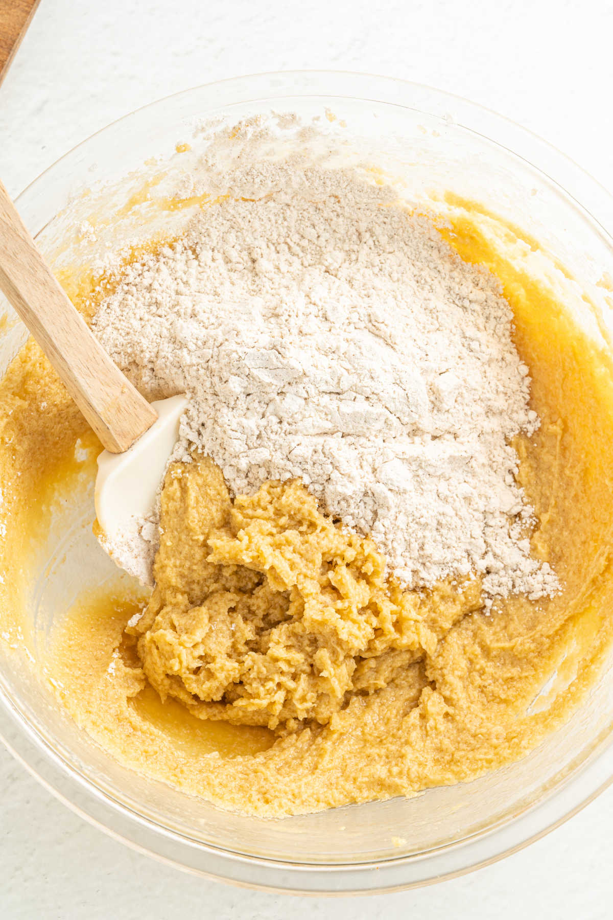 Mixing flour mixture into butter mixture to make cookie dough.