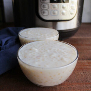 Two small glass bowls filled with vanilla tapioca pudding in front of an instant pot.