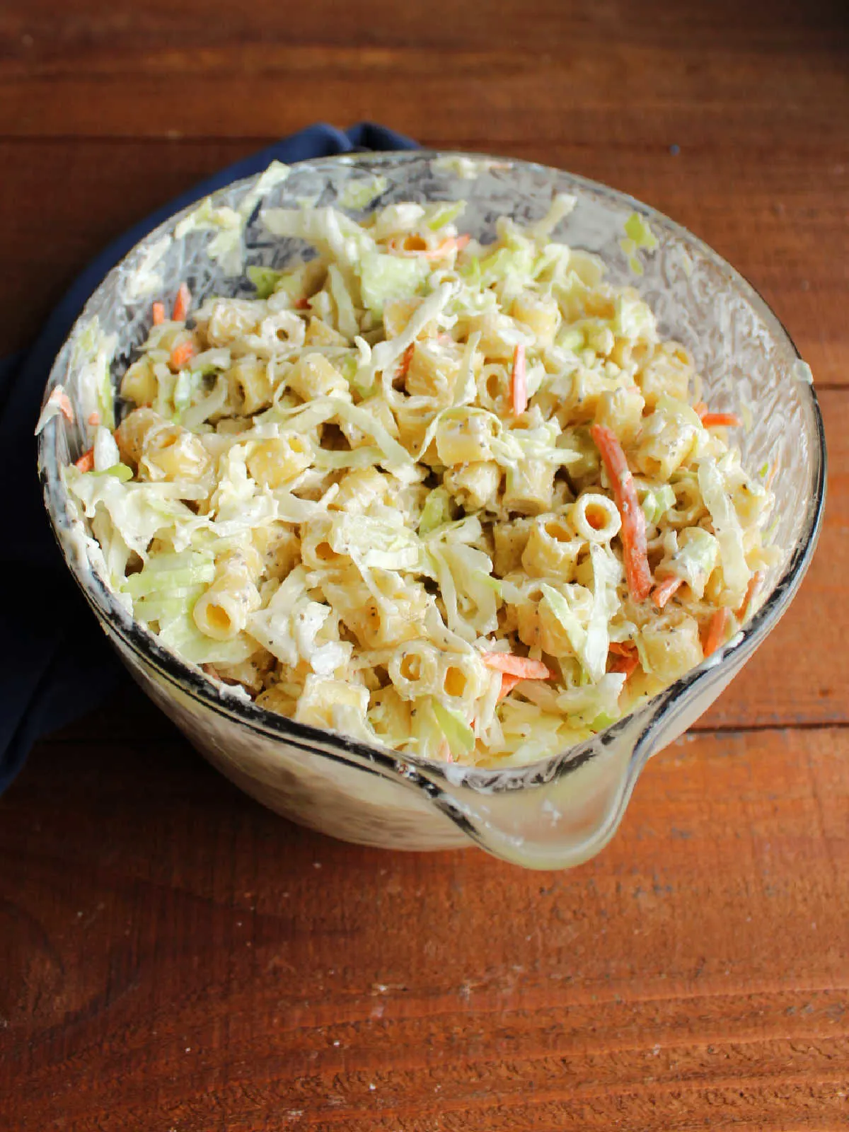 Bowl of coleslaw pasta salad after it has chilled for a couple of hours showing how the cabbage has softened and the volume has decreased a bit. 