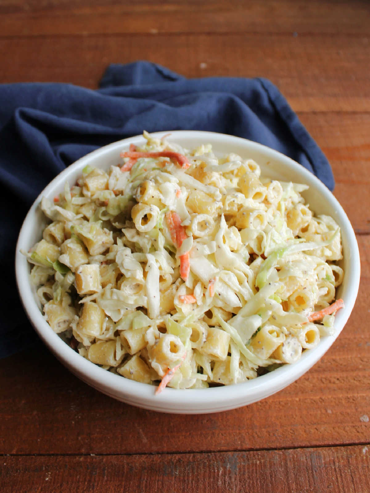 Serving bowl filled with creamy coleslaw macaroni salad.