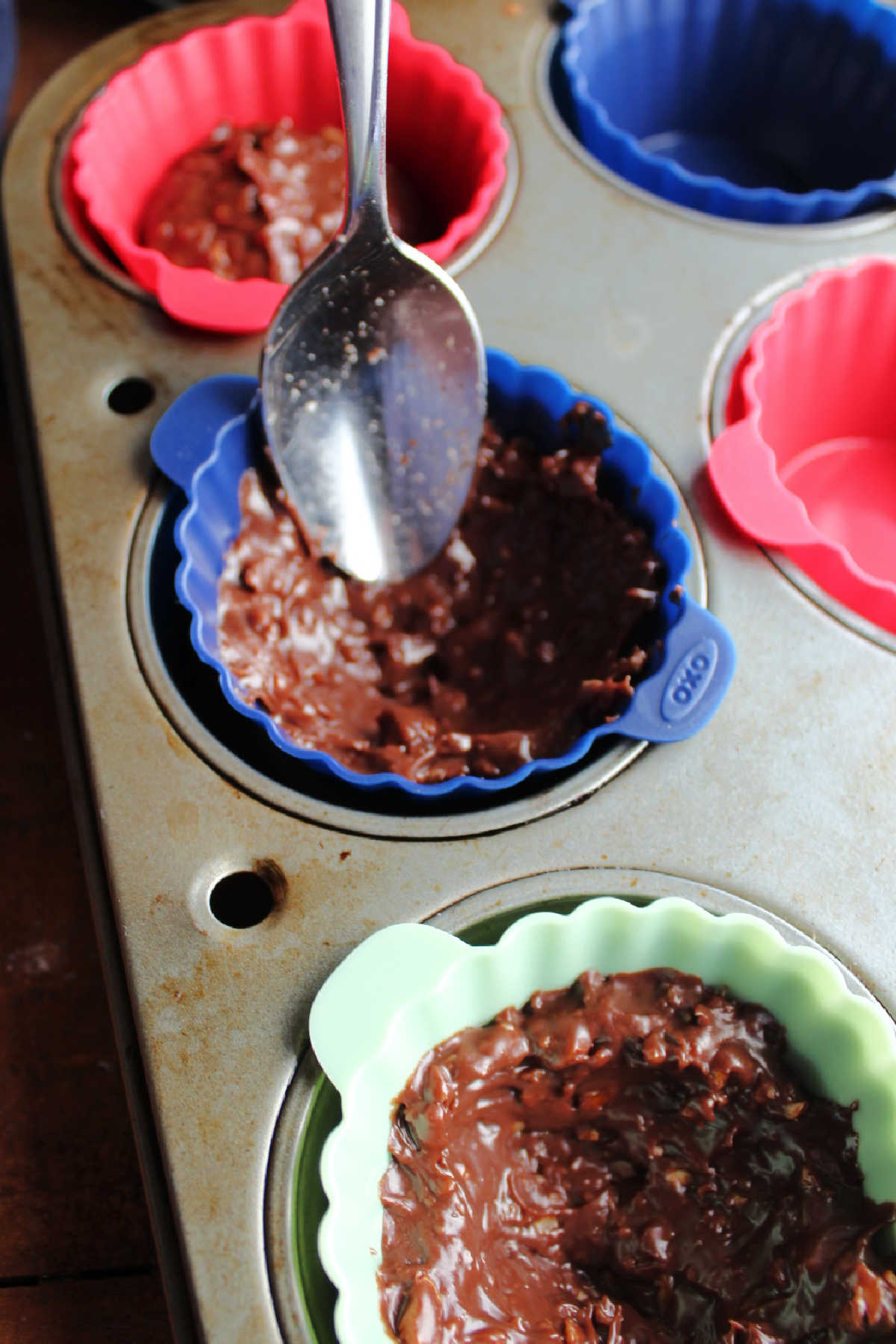 Using a spoon to form the chocolate mixture into a cup.