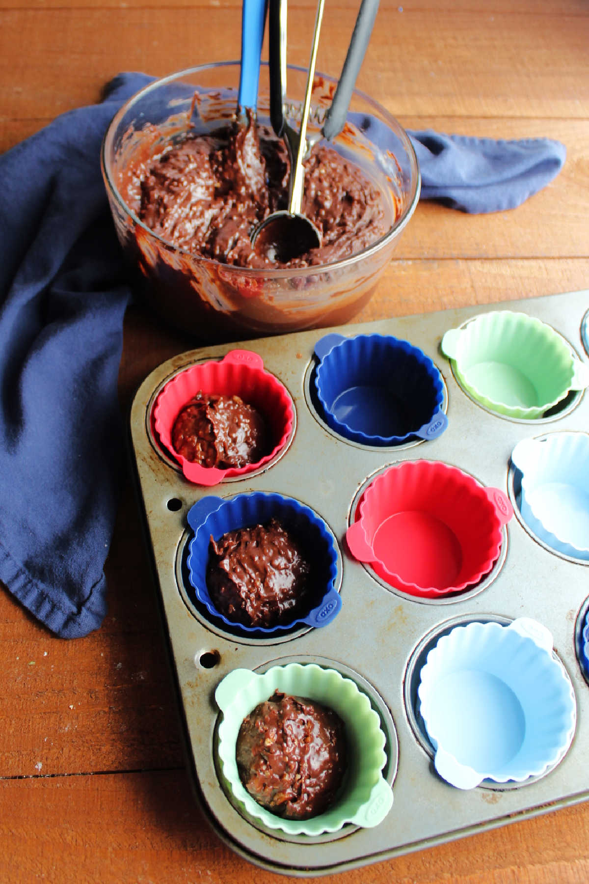 Scooping melted pecan fudge mixture into cupcake liners. 