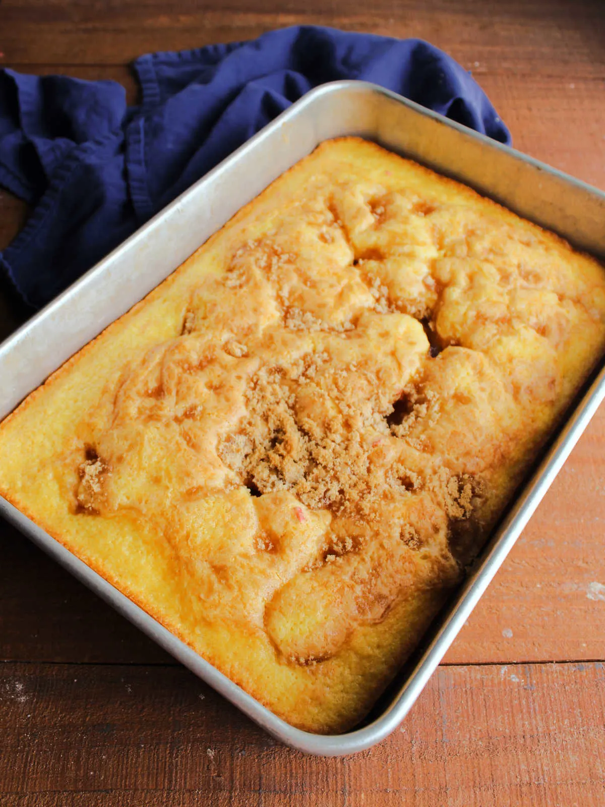 Freshly baked cake mix fruit cocktail cake with golden brown sugar topping.