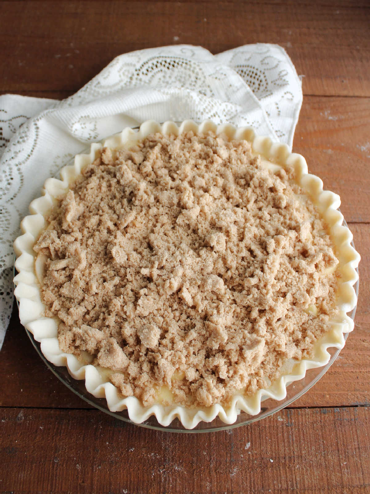 Pie covered in brown sugar streusel mixture, ready to go in the oven.