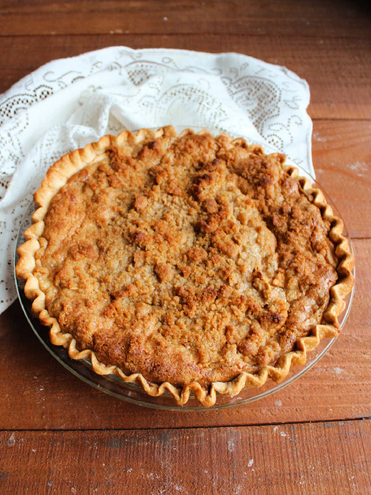 Fresh baked condensed milk apple pie showing the golden brown pie crust and browned streusel topping.