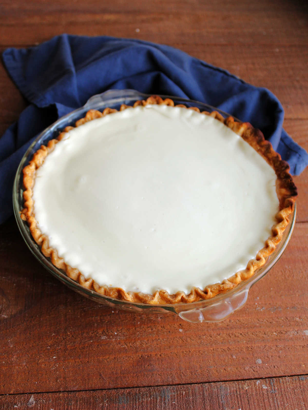Baked and cooled layered pumpkin pie showing smooth sour cream layer on top.