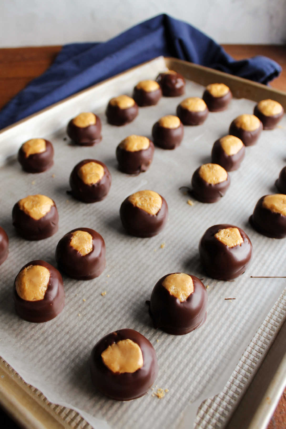 Tray of chocolate dipped peanut butter balls setting up.
