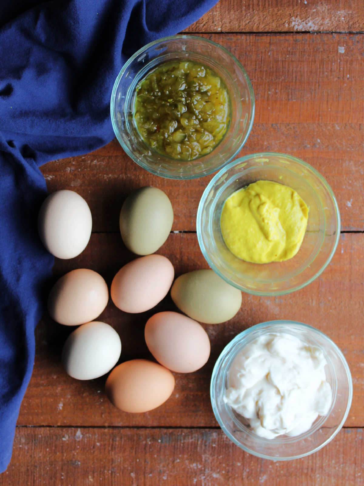 Ingredients including hard boiled eggs, pickle relish, yellow mustard, and mayonnaise, ready to be made into egg salad.