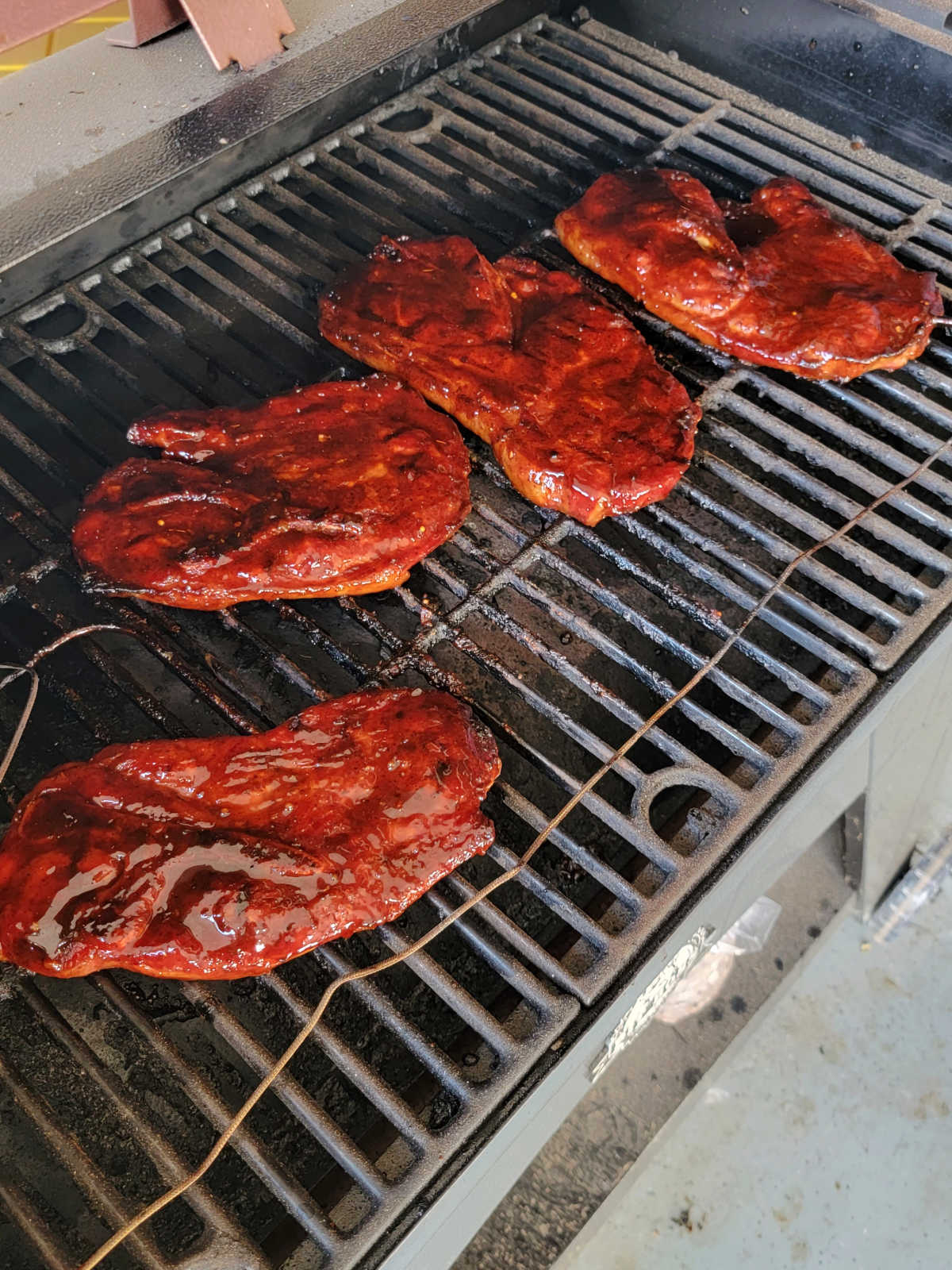 Sauced bbq pork steaks are back on the grill grates, they are tender and now just need some caramelization.