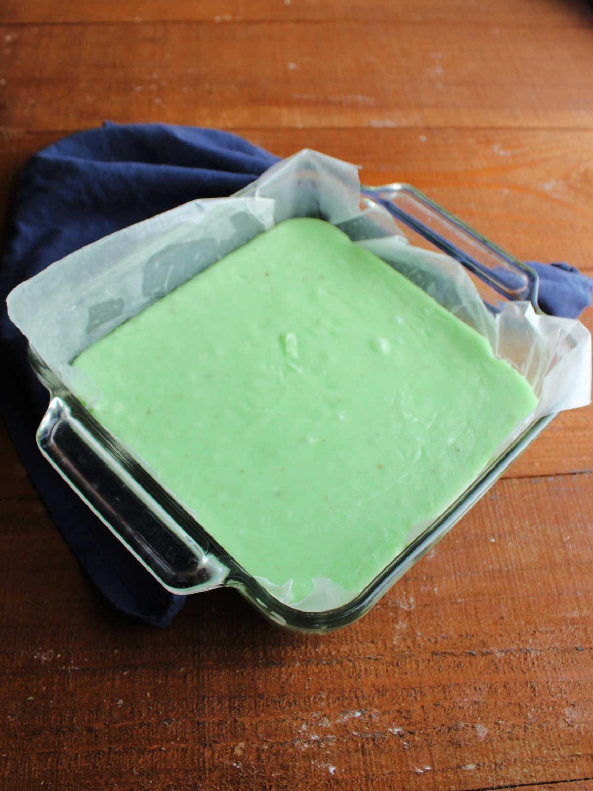 Square pan with green jello fudge inside.