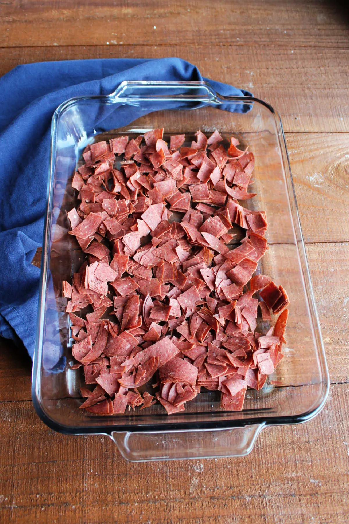 Chopped dried beef in the bottom of a glass 9x13-inch pan.