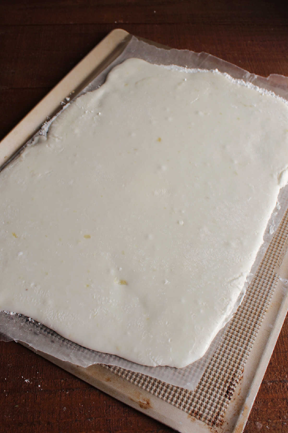 Mashed potato mixture rolled into a thin rectangle on a sheet of wax paper.