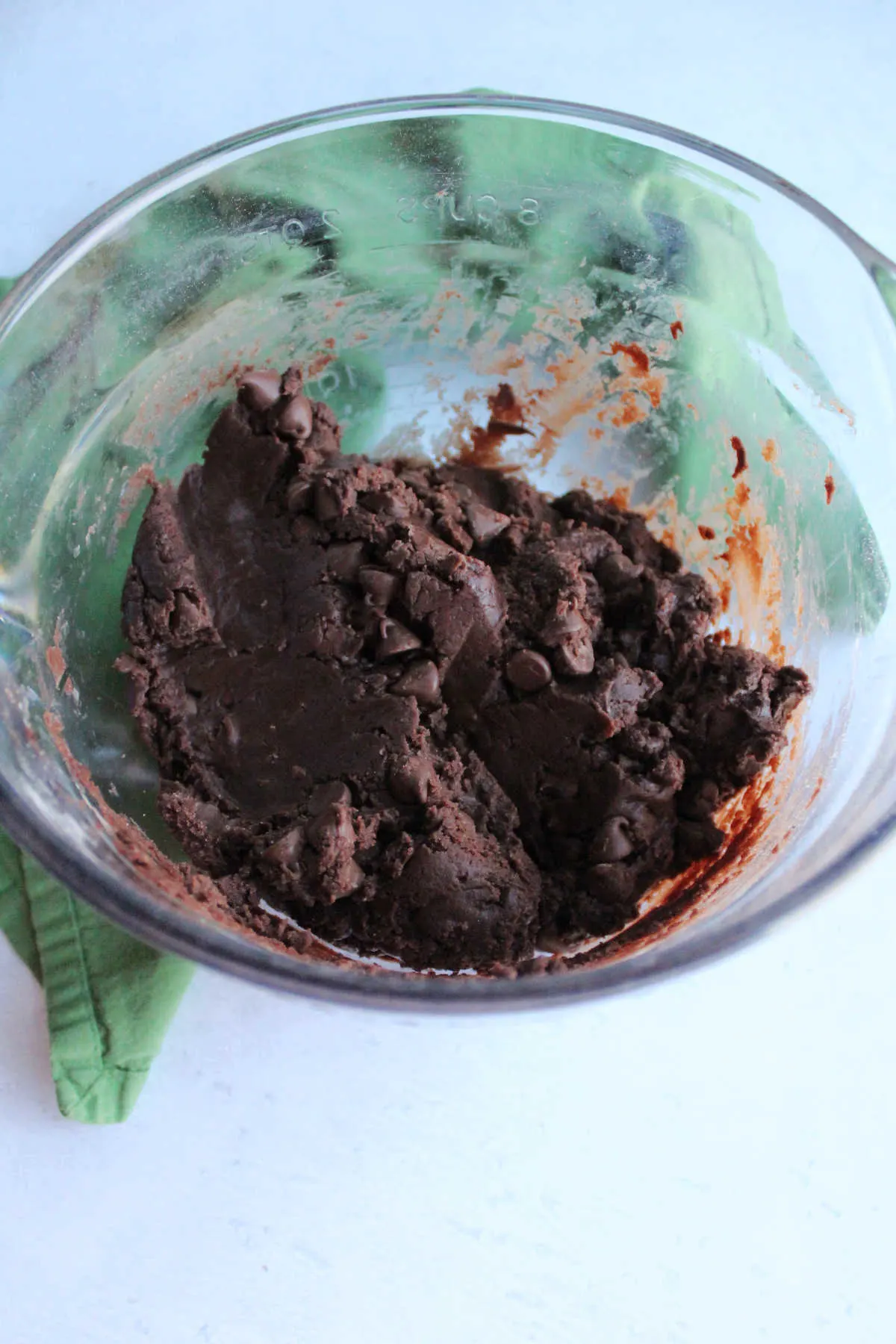 Bowl of thick chocolate cookie dough with chocolate chips.