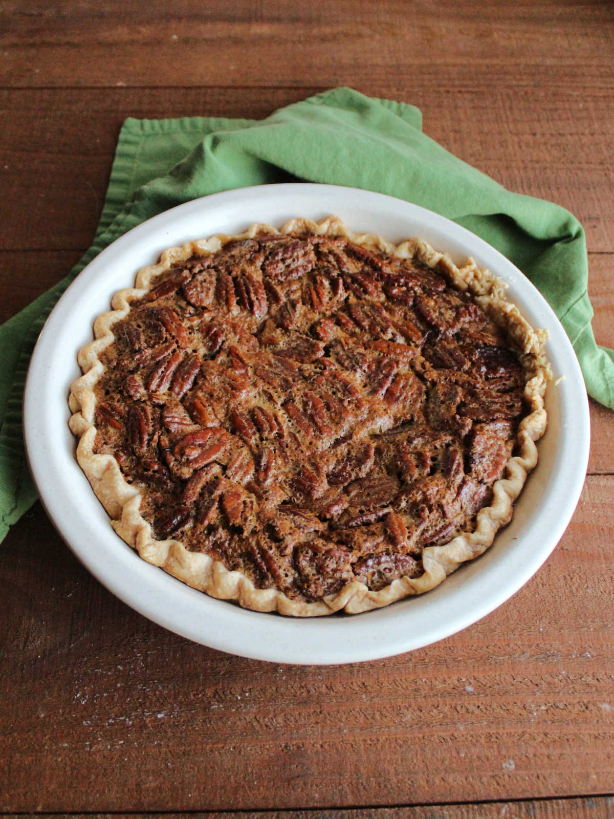 Freshly baked pecan pie with golden brown crusty top filled with lots of nuts.