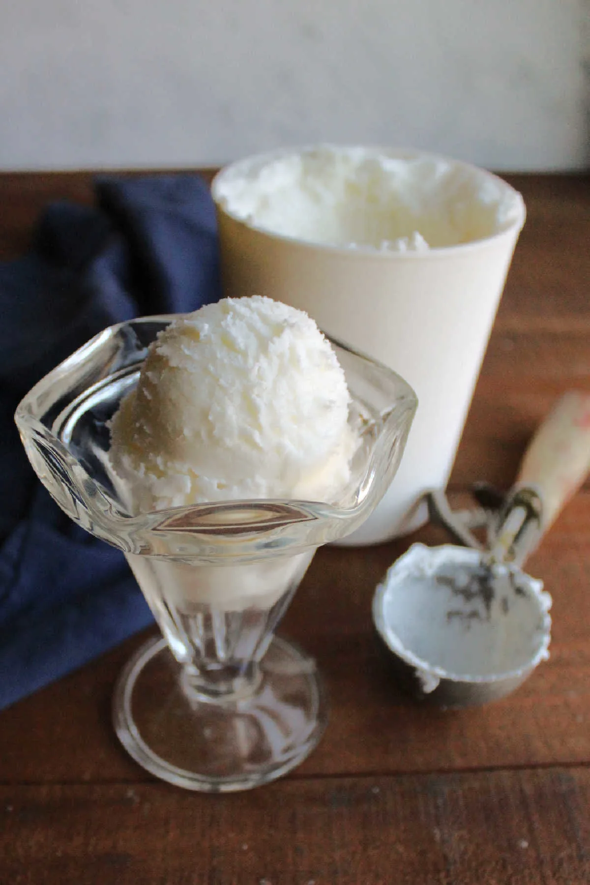 scoop of vanilla ice cream in sundae cup, ready to eat.