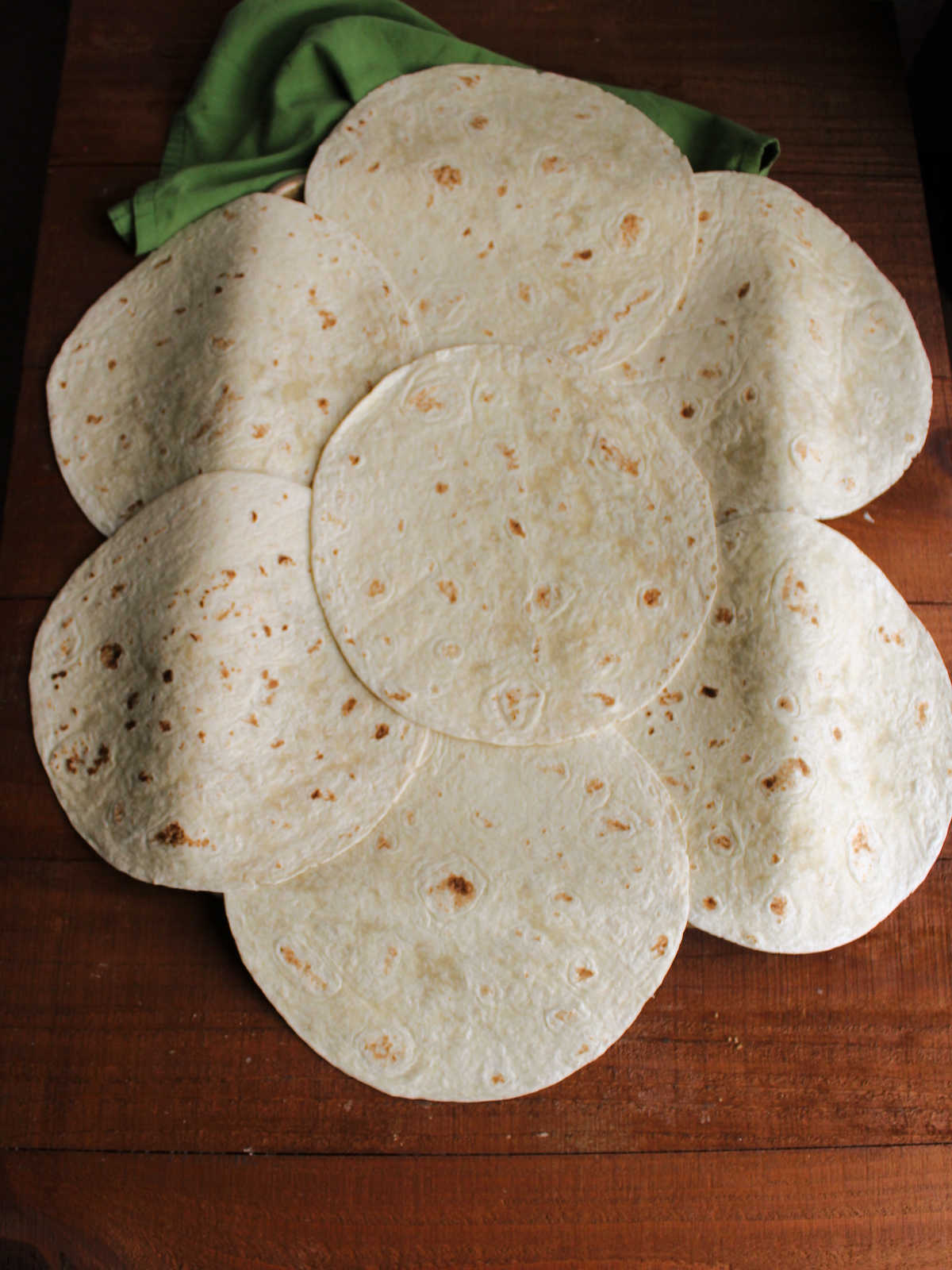 Sheet pan covered with large tortillas to make the bottom of the quesadilla.