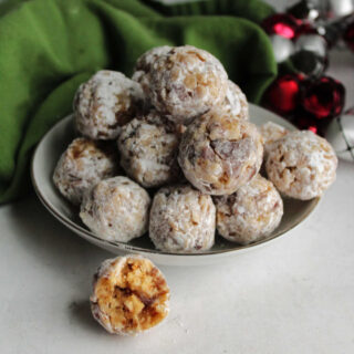 Small bowl of classic date balls coated in powdered sugar, ready to eat.