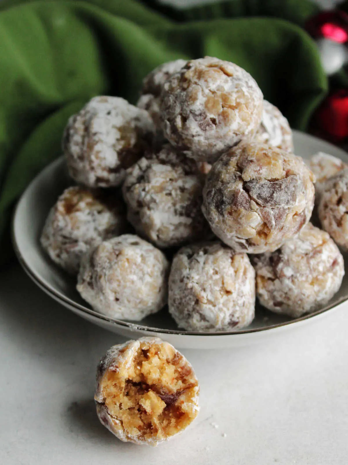 Small bowl of classic date balls coated in powdered sugar, ready to eat. 