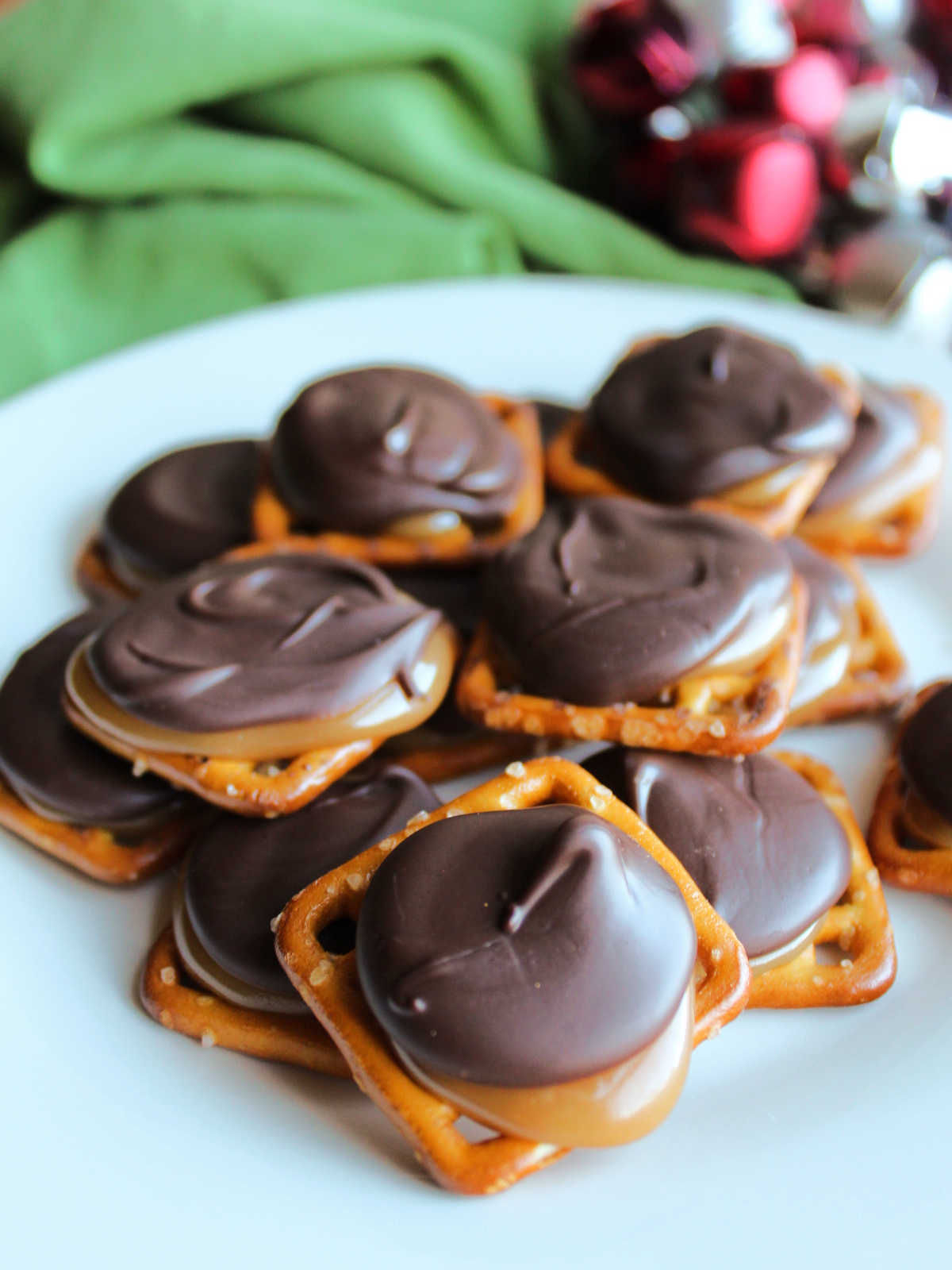 Plate of faux turtles made out of pretzels, homemade caramel, and chocolate, ready to eat. 