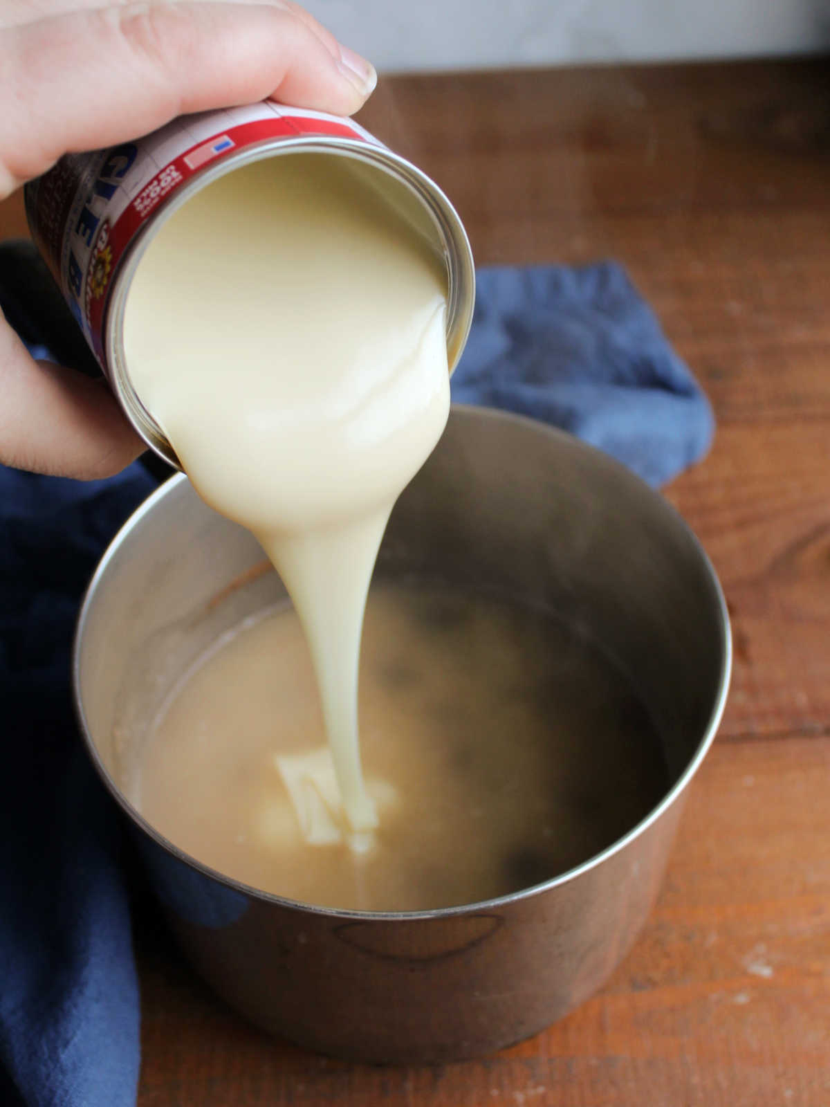 Adding a can of sweetened condensed milk to the rice mixture in the saucepan after the water has been brought to a boil.