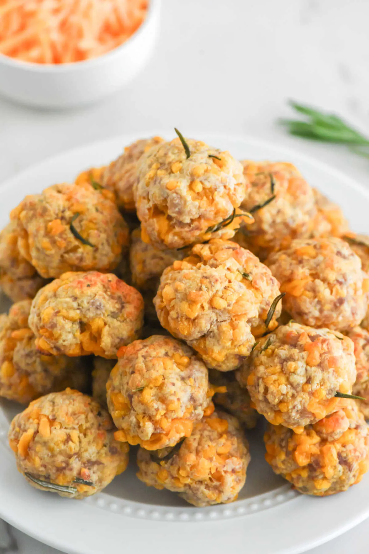Pile of cheesy bisquick sausage balls on a plate, ready to eat. 