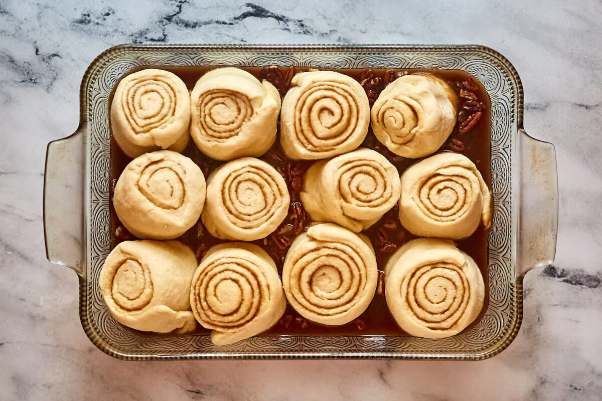 Proofed cinnamon rolls in pan, showing how they puffed up and are now ready to bake.