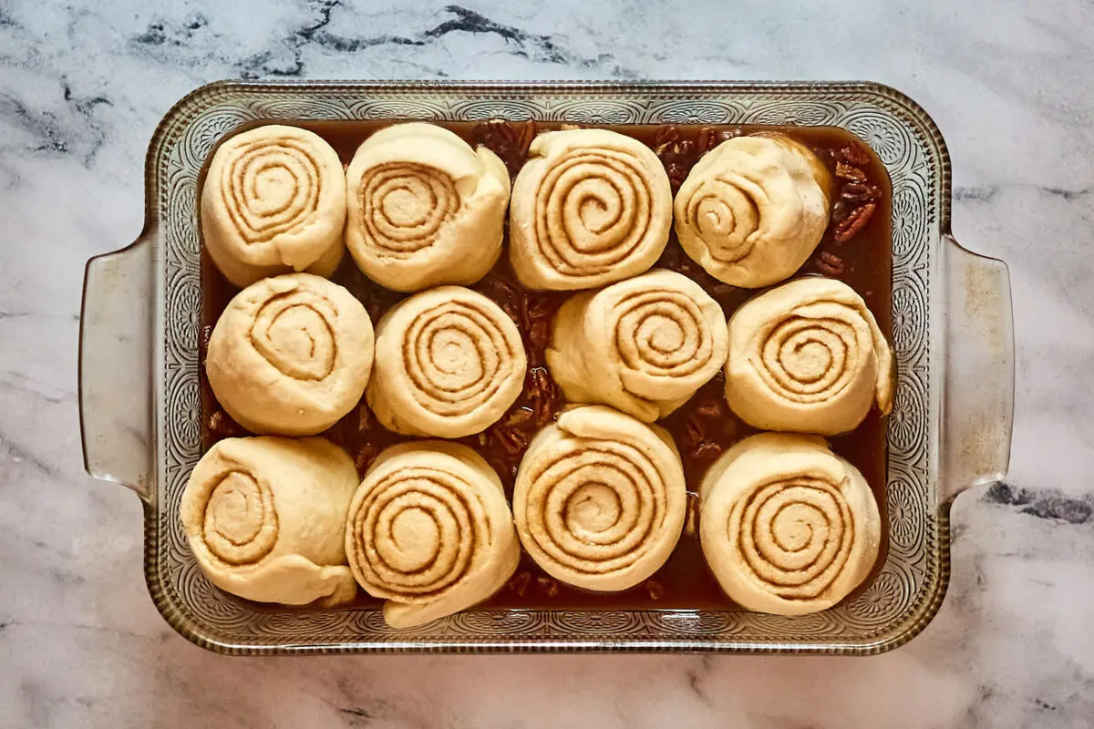 Proofed cinnamon rolls in pan, showing how they puffed up and are now ready to bake.
