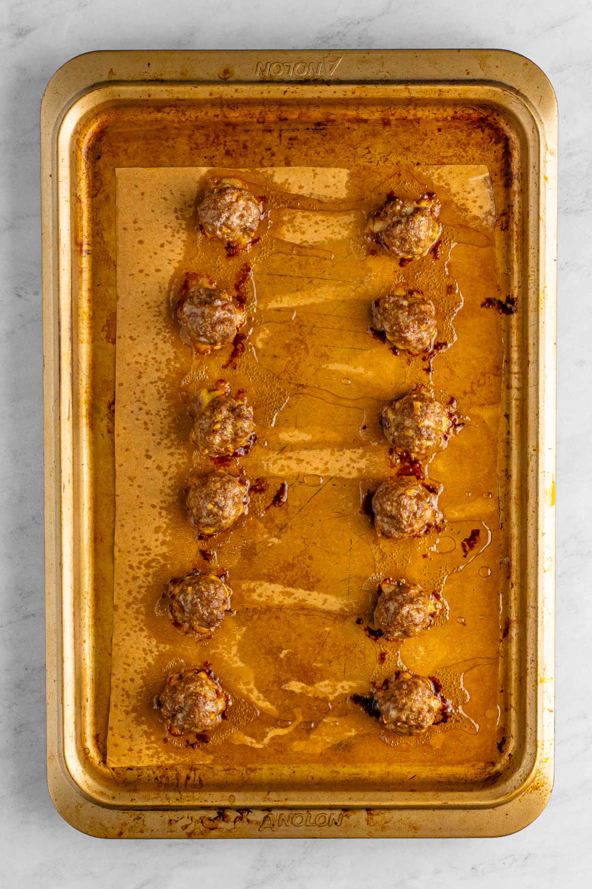 Freshly cooked meatballs on the pan, showing their browned color, ready to be made into sliders.