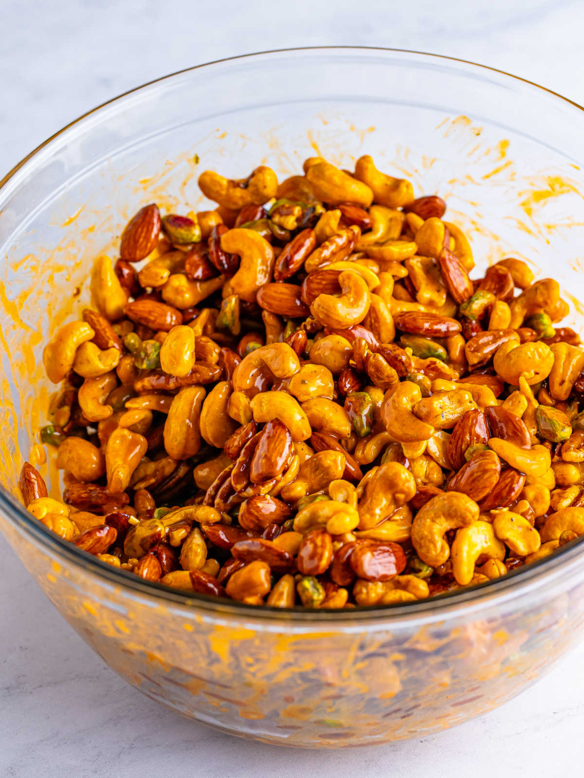 Bowl of mixed nuts coated in buffalo ranch sauce.