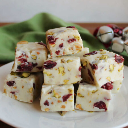 4 Ingredient Cranberry Pistachio Fudge 1 Plate of creamy vanilla fudge with dried cranberries and pistachio pieces inside.