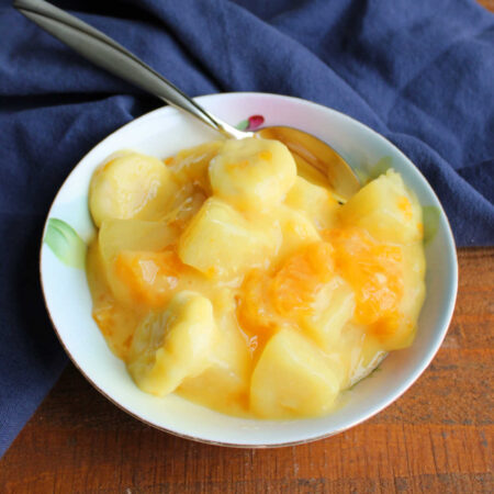 Sunshine Fruit Salad 1 Small bowl filled with fruit salad made from bananas, mandarin oranges, and pineapple in creamy vanilla pudding dressing.