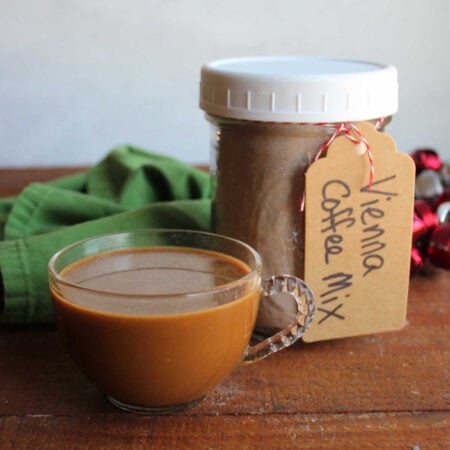 Jar of homemade cafe vienna mix next to a mug of vienna coffee ready to drink.