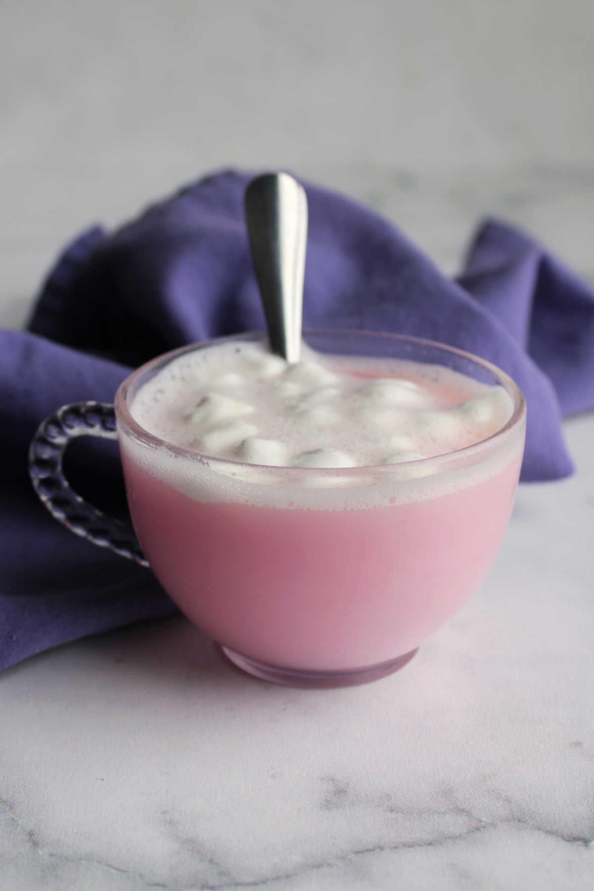Mug of strawberry hot chocolate made with hot water and the pink hot chocolate mix topped with marshmallows, ready to drink. 
