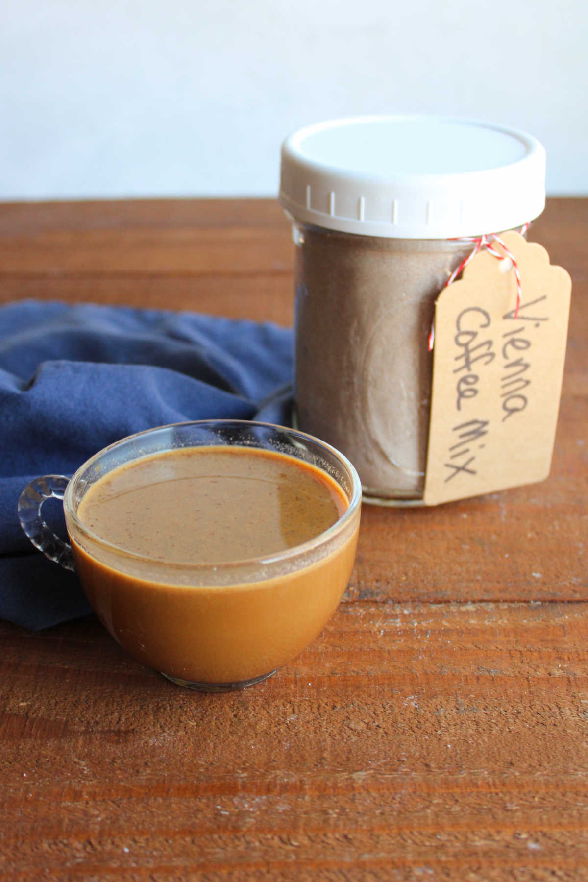 Glass mug of viennese coffee next to a jar of the homemade mix. 