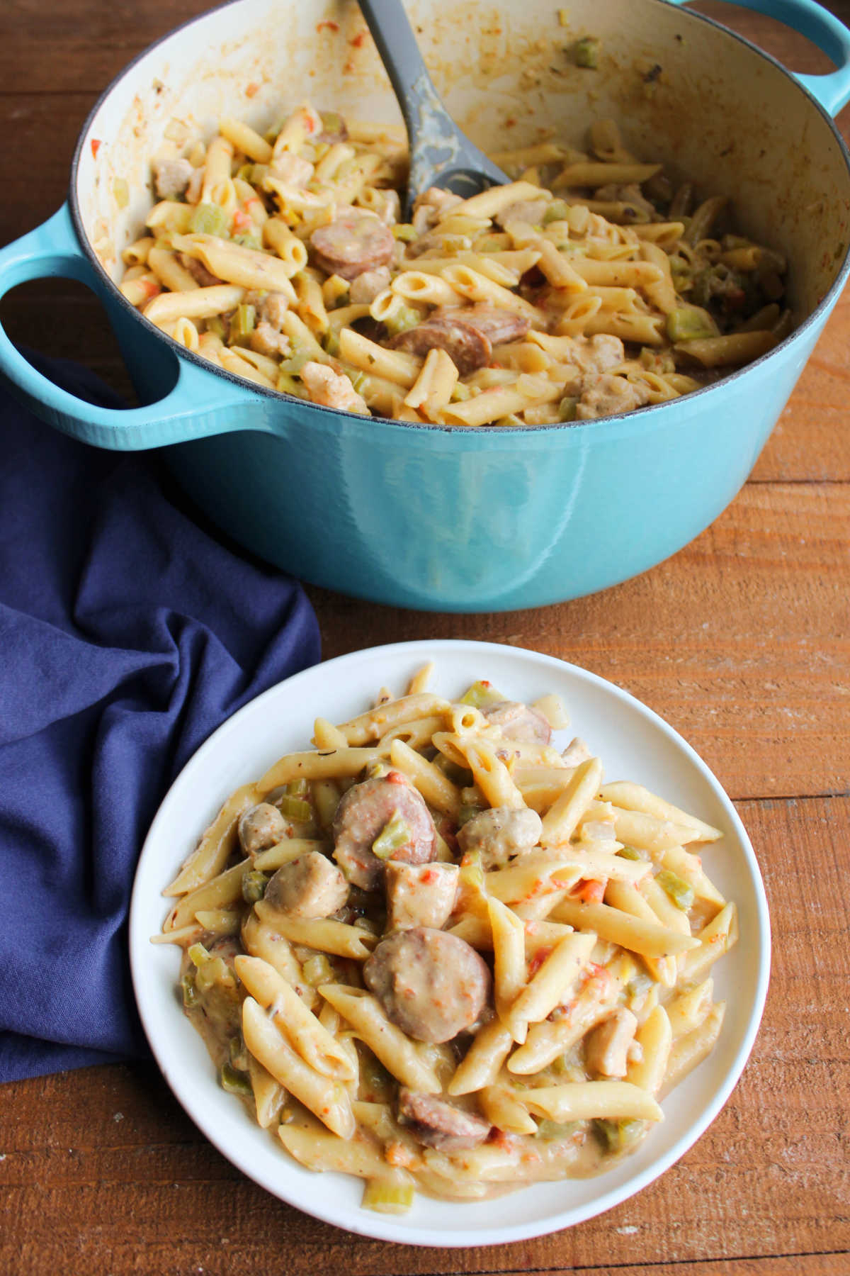 Plate of pastalaya that is ready to eat next to the pot it was cooked in. 