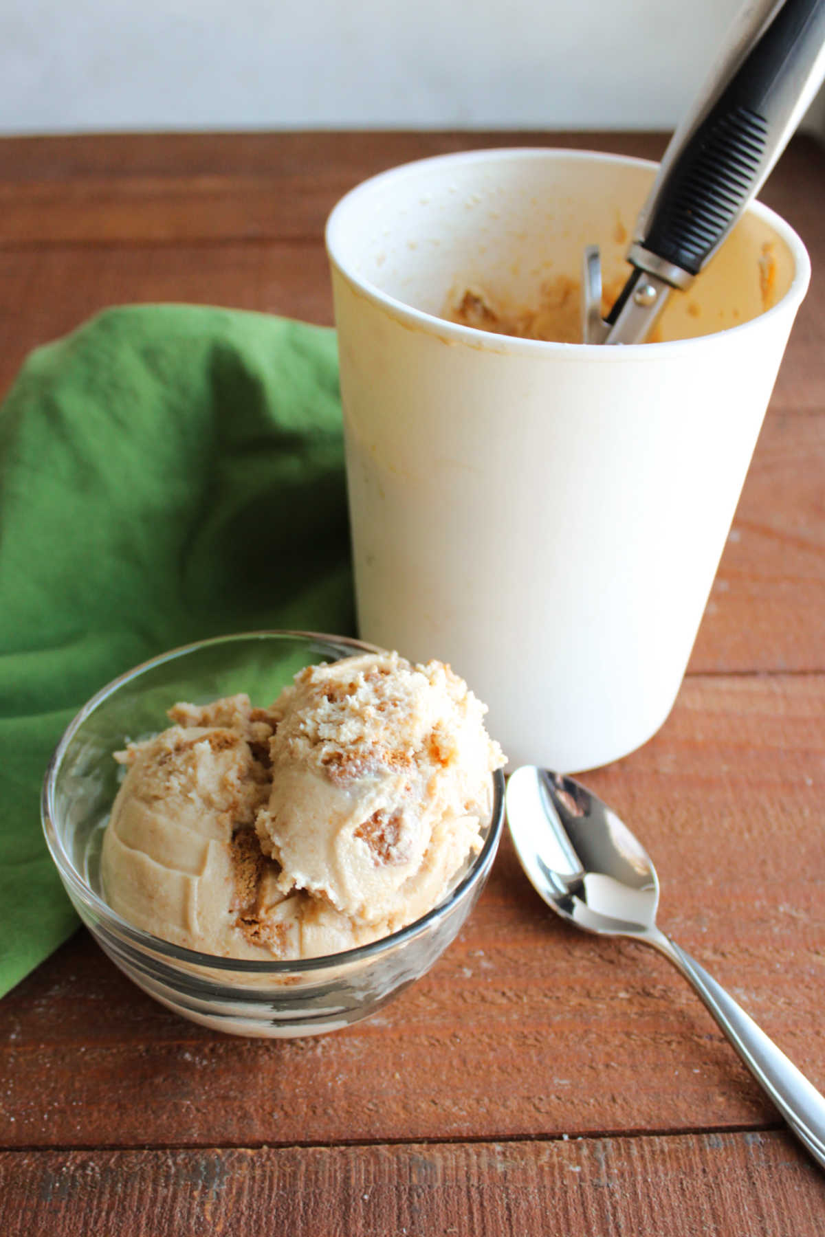 Biscoff Ice Cream 6 Small bowl of homemade biscoff ice cream next to the ice cream storage container it was frozen in.