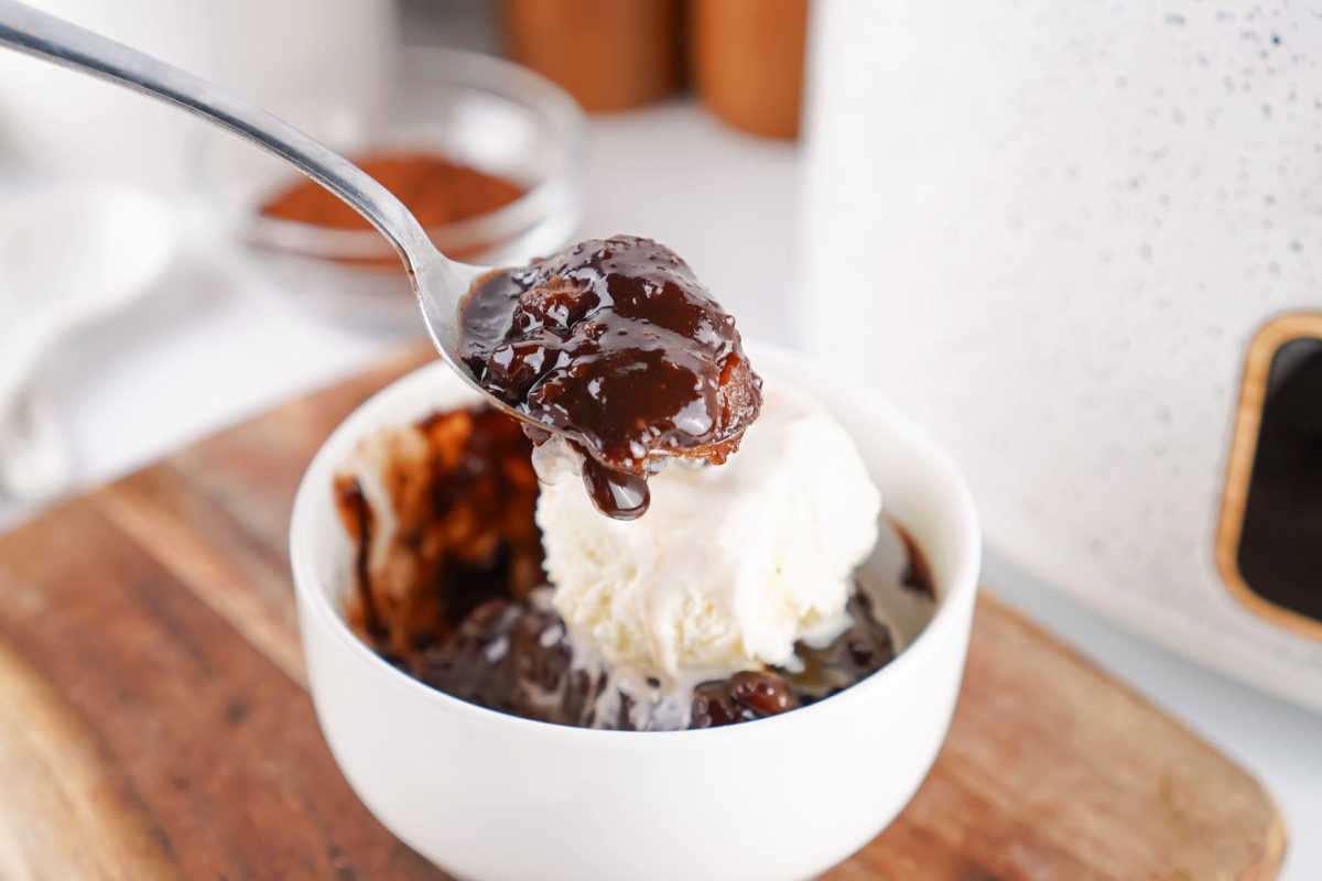 Crockpot Chocolate Cobbler 6 Spoon with a bite of gooey crockpot chocolate cobbler, ready to eat.