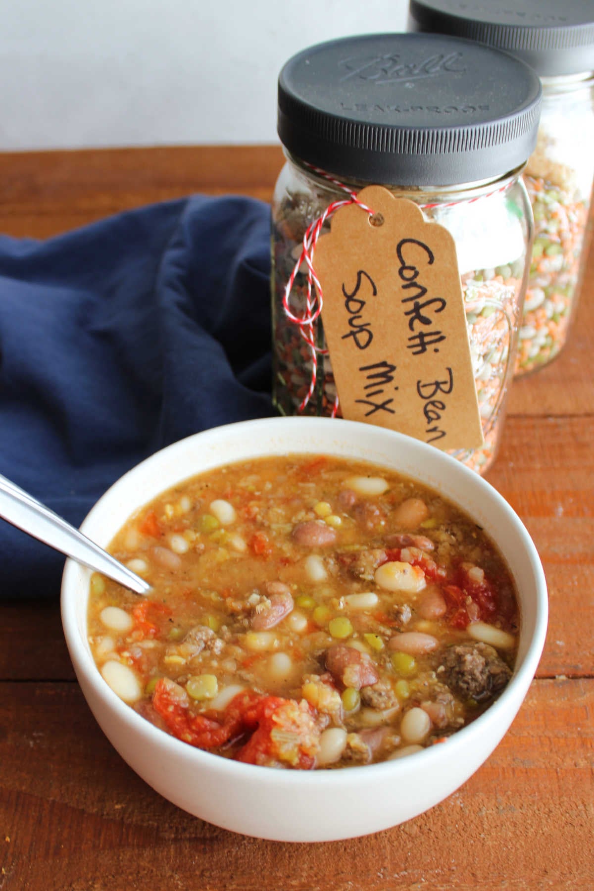 Confetti Bean Soup Mix In A Jar 9 Bowl of confetti bean soup next to a couple of quart jars with homemade bean soup mix inside.