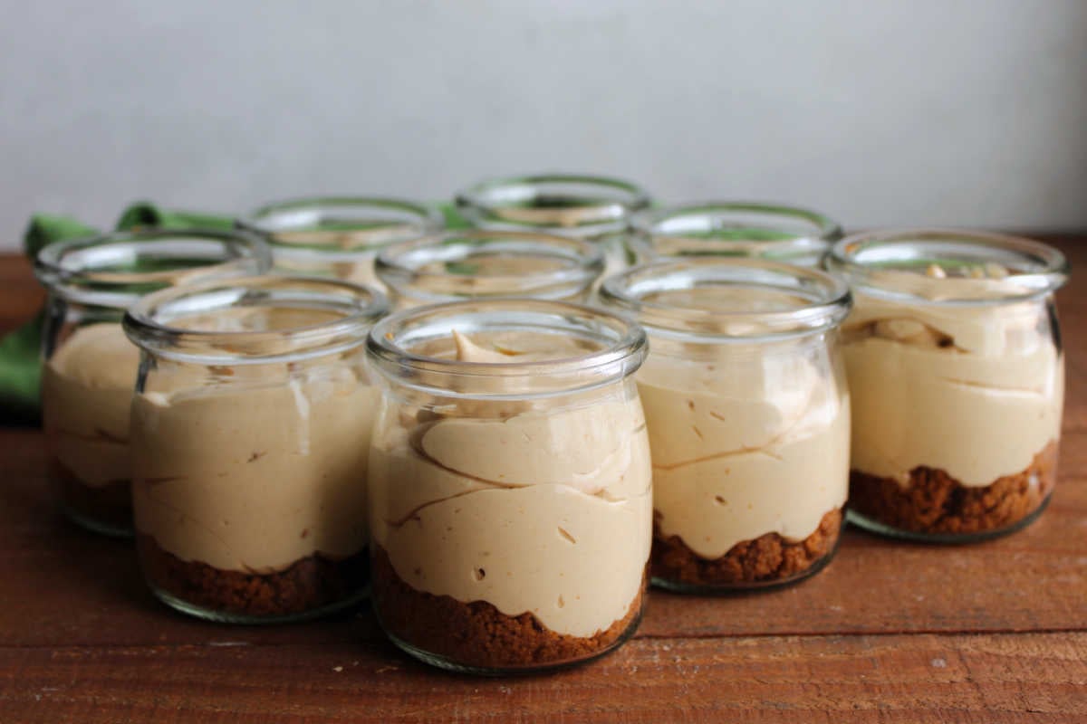 No Bake Biscoff Cheesecake Jars 7 A bunch of glass jars filled with cookie butter cheesecake with Biscoff cookie crusts, ready to eat.