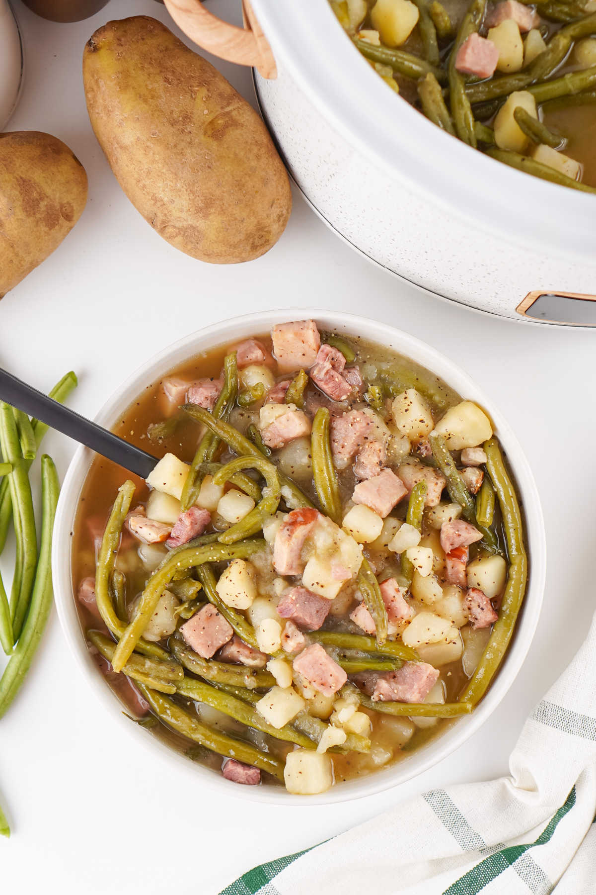 Crockpot Green Beans With Ham and Potatoes 7 Bowl of green beans with ham and potatoes, ready to eat.
